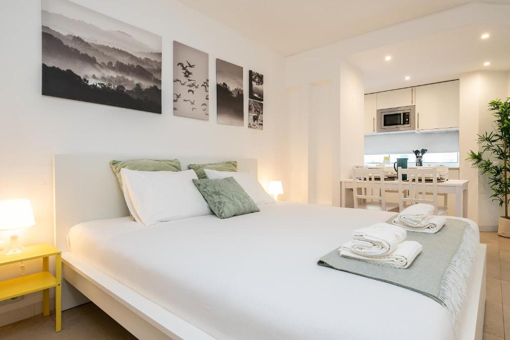 Bright apartment interior with double bed, dining table and open kitchen