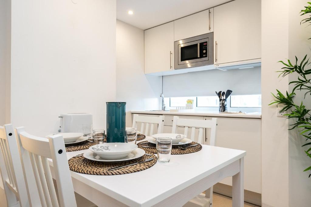 Mesa de refeições para quatro pessoas junto à cozinha do apartamento