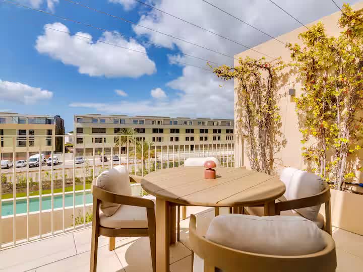 Furnished balcony overlooking the pool and landscaped complex